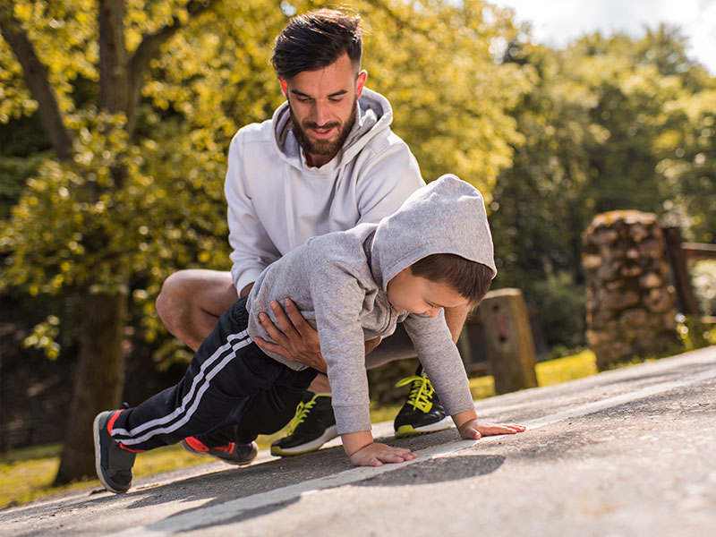 Father helping his son exercise