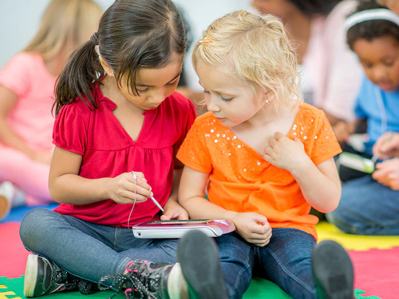 Two young girls using an iPad