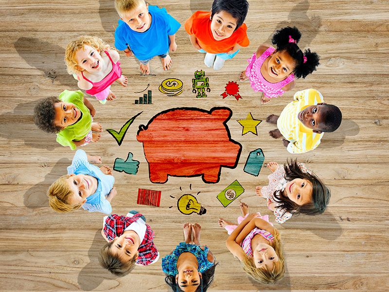 Eleven children around a piggy bank learning about saving